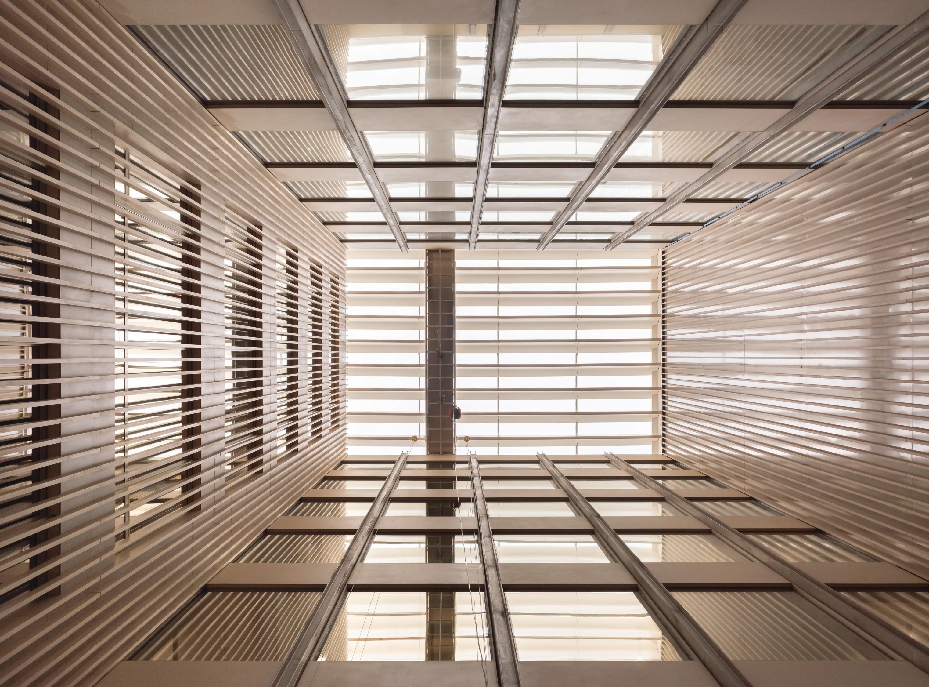 Castellana 14 — atrio interior con celosía de lamas y lucernario